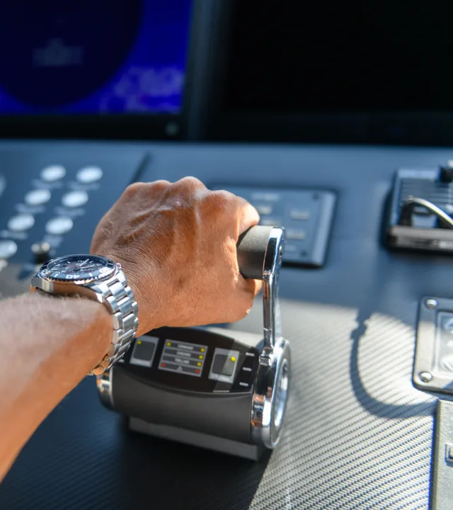 A hand on the throttle at a yacht’s helm