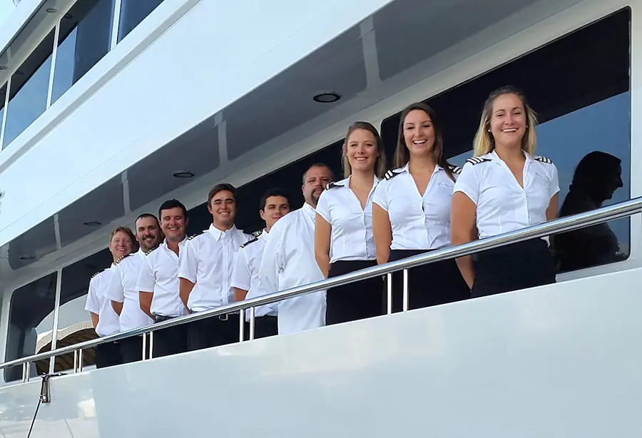 Uniformed superyacht crew standing together on deck